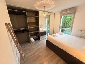 Un dormitorio con una cama grande y una ventana grande. en Appartement récent tout confort, en Caen