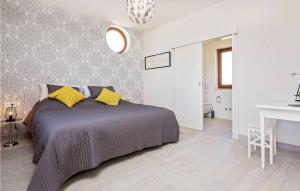 a bedroom with a bed with yellow pillows at Villa Fortuna in Funtana