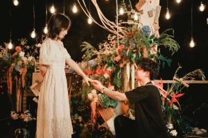 a man holding the hand of a woman in front of a flower arrangement at Xishang Yunjian Holiday Hotel in Hangzhou