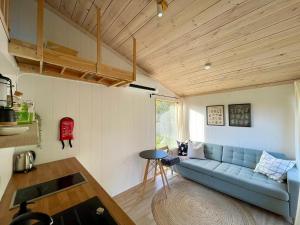 a living room with a blue couch and a table at Paluküla Saunad tiny house Kadaka - sauna, hot tub in Paluküla