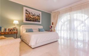 a bedroom with a white bed and a large window at Lovely Home In Málaga in Málaga