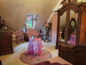 ein Wohnzimmer mit einem Tisch mit Blumen darauf in der Unterkunft Chambre d hôte les bosquets in Caugé