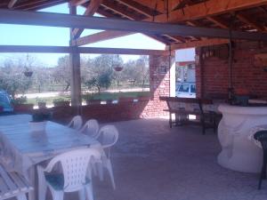 a patio with white tables and chairs and a brick wall at Apartments Buzleta in Fažana
