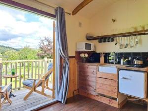 a kitchen with a view of a deck with a balcony at Puddleduck Hut Armathwaite with hot tub and dog agility course, perfect for a romantic break in Armathwaite