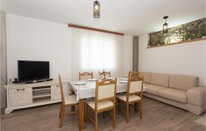 a living room with a dining room table and a couch at 3 Bedroom Stunning Home In Tijarica in Vukići