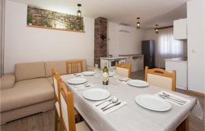 a dining room with a table and a couch at 3 Bedroom Stunning Home In Tijarica in Vukići
