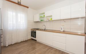 a kitchen with white cabinets and a sink at 3 Bedroom Stunning Home In Tijarica in Vukići