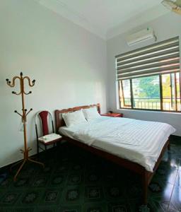 una camera da letto con un letto, una sedia e una finestra di Gia Linh Homestay a Cao Bằng