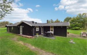 a black shed with a picnic table in a yard at Lovely Home In Strandby With Kitchen in Strandby +9 photos