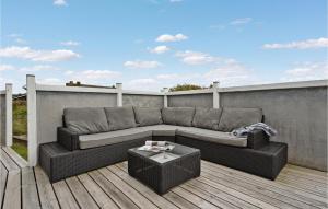a couch sitting on a deck on a patio at Beautiful Home In Ringkøbing With Sauna in Klegod +28 photos