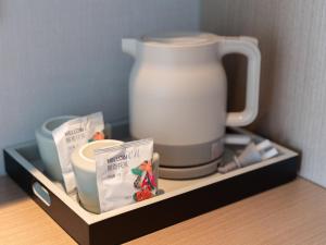 Příslušenství pro přípravu čaje a kávy v ubytování Lavender Hotel Xinle Shijiazhuang Airport Hebei Academy of Fine Arts