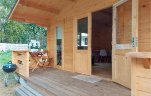 a wooden cabin with a deck with a grill at Stunning Home In Pobierowo With Kitchen in Pobierowo +9 photos