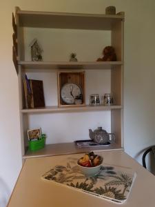a kitchen counter with a bowl of fruit and a clock at La Petite Maison du Gardien in Sainte-Agnès