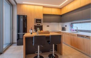 a kitchen with a island with two bar stools at Beautiful Home In Heraklio Crete in Lygaria