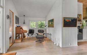 a living room with a chair and a desk at Amazing Home In Samsø With Sauna in Nordby +12 photos