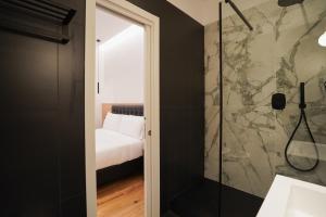 a bathroom with a walk in shower next to a bedroom at No Man's Land Guesthouse in Rome