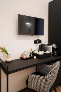 a black table with two chairs and a television on a wall at No Man's Land Guesthouse in Rome +71 photos