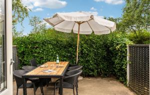 un tavolo di legno con un ombrellone su un patio di 3 Bedroom Cozy Home In Juelsminde a Sønderby Altre 13 foto
