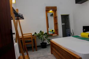 a bedroom with a bed and a desk and a mirror at Cozy Resort in Matara