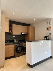 a kitchen with a stove and a dishwasher at Luxury Garden Apartment by the Beach in Tamraght Ouzdar