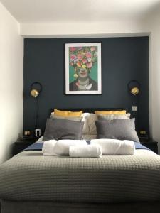 a bedroom with a large bed with a painting on the wall at The Metropolitan Guest House in Whitley Bay +14 photos