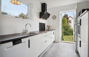 a white kitchen with a sink and a window at 2 Bedroom Cozy Home In Ryomgård in Ryomgård