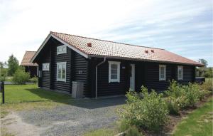 a black house with a red roof at Holiday Home Marielyst Strandpark Væggerløse Ii in Marielyst