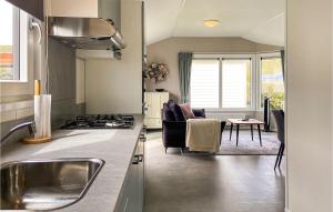a kitchen and living room with a stove top oven at Lovely Stacaravan In Julianadorp in Julianadorp