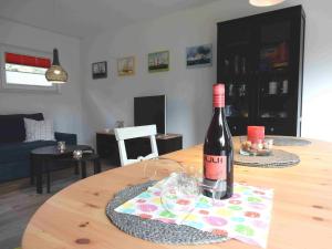 a bottle of wine sitting on top of a wooden table at Haus am Nordstrand 2 in Prerow