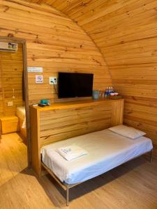 Habitación con cama y TV en una cabaña en Sea Mountain Bungalow Vũng Tàu, en Vung Tau
