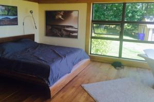 a bedroom with a bed and two large windows at Spacious luxurious Villa, bright cottage, pool, Jacuzzi, sauna, nature in Mansonville +49 photos