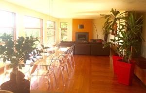 a living room with a table and chairs and plants at Spacious luxurious Villa, bright cottage, pool, Jacuzzi, sauna, nature in Mansonville