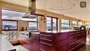 a large kitchen with purple cabinets and windows at Spacious luxurious Villa, bright cottage, pool, Jacuzzi, sauna, nature in Mansonville