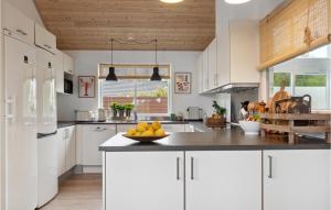 a kitchen with white cabinets and a bowl of fruit on a counter at Amazing Home In Tisvildeleje With Sauna in Tisvildeleje