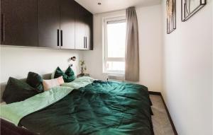 ein Schlafzimmer mit einem Bett mit einer grünen Decke darauf in der Unterkunft Gorgeous Home In Heinkenszand With Wifi in Heinkensand + 14 Fotos