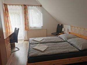 a bedroom with a bed and a desk and a window at Kiss Vendégház in Balatonlelle +5 photos