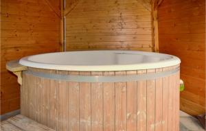 una vasca da bagno in legno in una stanza in legno di Nice Home In Brodnica Górna With Sauna a Brodnica Dolna