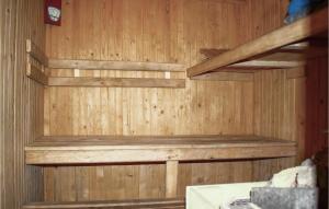 una parete di legno in una sauna con ripiani in legno di Nice Home In Brodnica Górna With Sauna a Brodnica Dolna Altre 14 foto