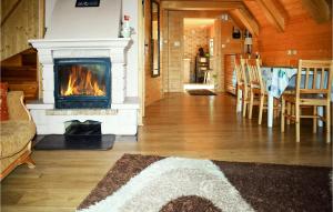un soggiorno con camino, tavolo e sedie di Nice Home In Brodnica Górna With Sauna a Brodnica Dolna
