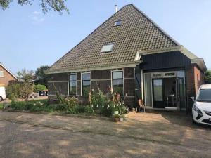 a house with a car parked in front of it at Appartement voor twee personen in Twisk