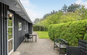 a patio with a table and chairs next to a building at Holiday Home Pramvej Hjørring in Lønstrup