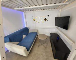 a small room with a blue couch and a tv at Daisy Bucolique #Parking #Terrasse #Calme in Irigny