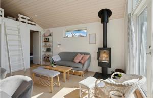 a living room with a couch and a fireplace at Amazing Home In Faxe Ladeplads With Wifi in Fakse Ladeplads
