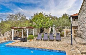 a swimming pool with lounge chairs and a house at Two-Bedroom Holiday Home In Drvenik Veli in Veliki Drvenik