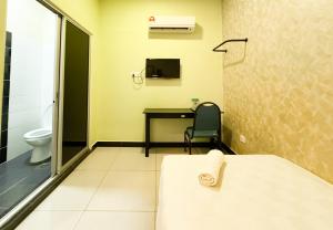 a bathroom with a bed and a desk and a toilet at Night Queen Express Hotel KLIA T1 and KLIA T2 in Sepang +62 photos