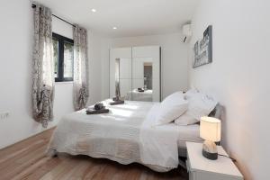 a white bedroom with a large bed and a bathroom at Villa Marconi in Potpićan