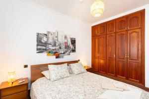 Un dormitorio con una cama grande y armarios de madera. en Home2Book Tranquil Spot Las Tanquillas, BBQ&Views, en Buenavista del Norte