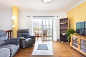 Una sala de estar con un sofá y un televisor. en Home2Book Tranquil Spot Las Tanquillas, BBQ&Views, en Buenavista del Norte