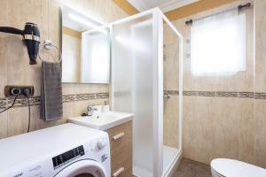 Un baño con lavadora y lavabo. en Home2Book Tranquil Spot Las Tanquillas, BBQ&Views, en Buenavista del Norte 27 fotos más