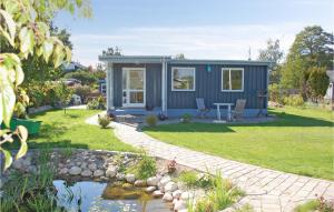 a blue tiny house in a yard with a pond at Two-Bedroom Holiday Home In Hornslet in Hornslet
